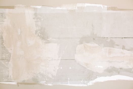 Close-up of an unfinished wall showing plaster and paint textures in a home renovation.
